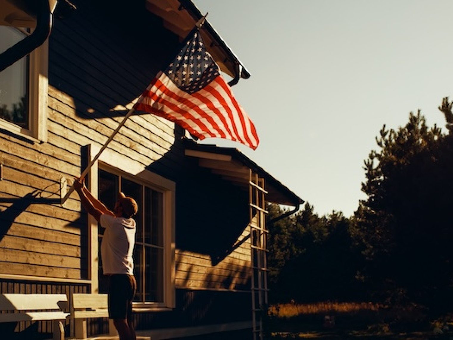 Man displaying the American flag on the outside of his home.